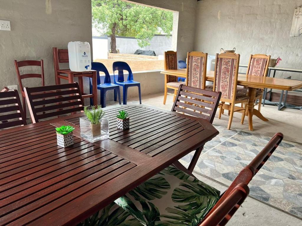 a wooden table and chairs in a room with tables and chairs at Rural Villa Guesthouse in Naledi