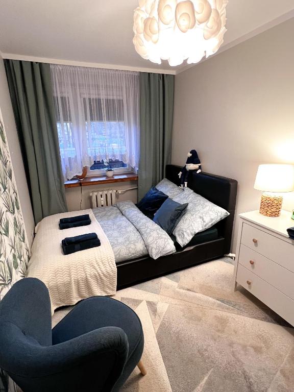 a bedroom with a bed and a chair in it at Apartament Sieroszewskiego in Puławy
