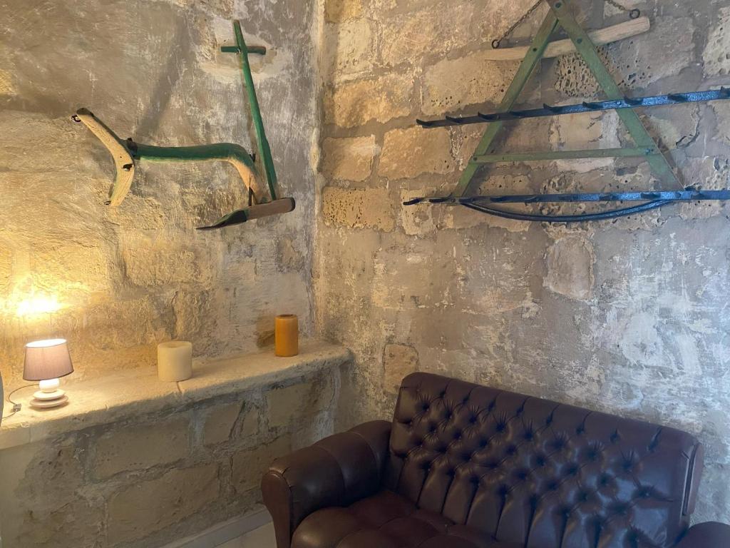 a living room with a couch and a wall with weapons at Fiftyfour West Boutique Living in Għarb