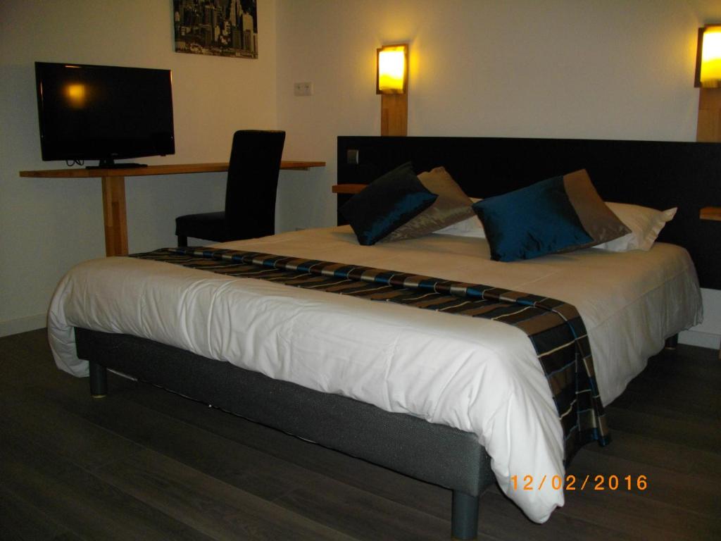 - une chambre avec un grand lit et une télévision murale dans l'établissement Appart'hotel Residella House Room & Kitchen Avignon Le Pontet, au Pontet