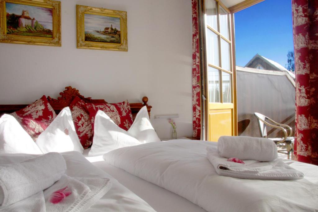 1 Schlafzimmer mit 2 Betten mit weißer Bettwäsche und einem Fenster in der Unterkunft Hotel Viktoria in Meersburg