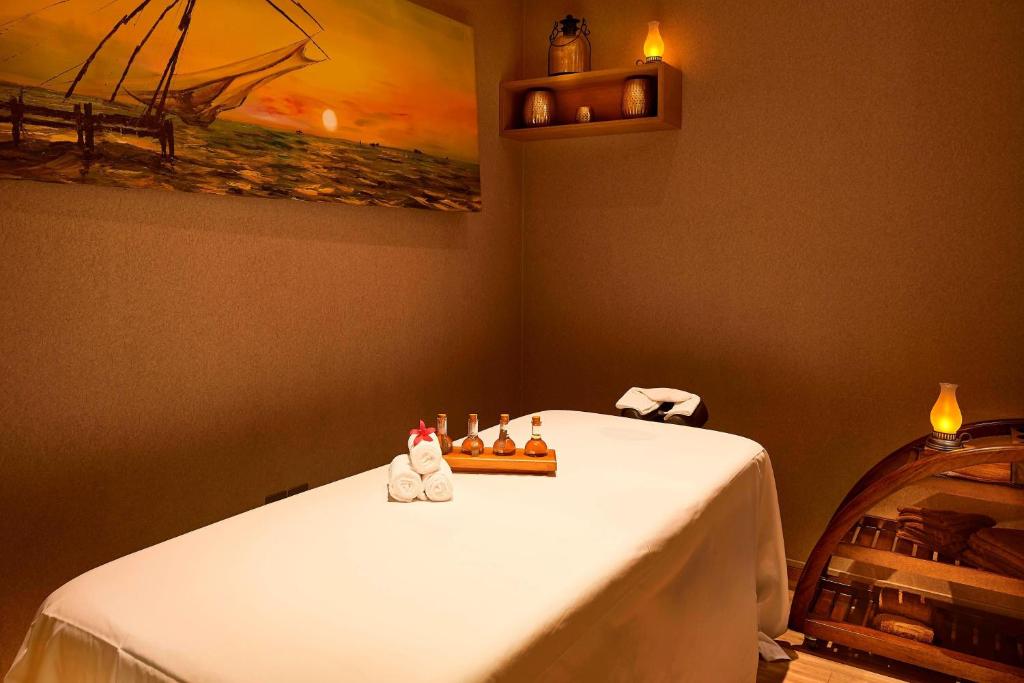 a table in a room with a white table cloth at Courtyard by Marriott Kochi Airport in Nedumbassery