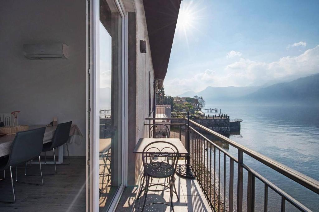 a balcony with a table and chairs and a view of the water at Le Coccinelle Home Lovely View in Lierna