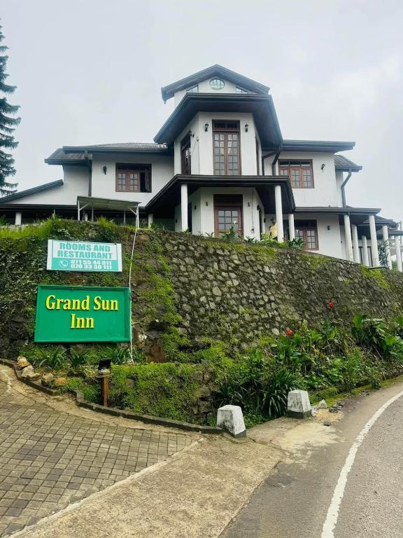 a house on a hill with a sign in front of it at Hotel Grand Sun Inn in Nuwara Eliya