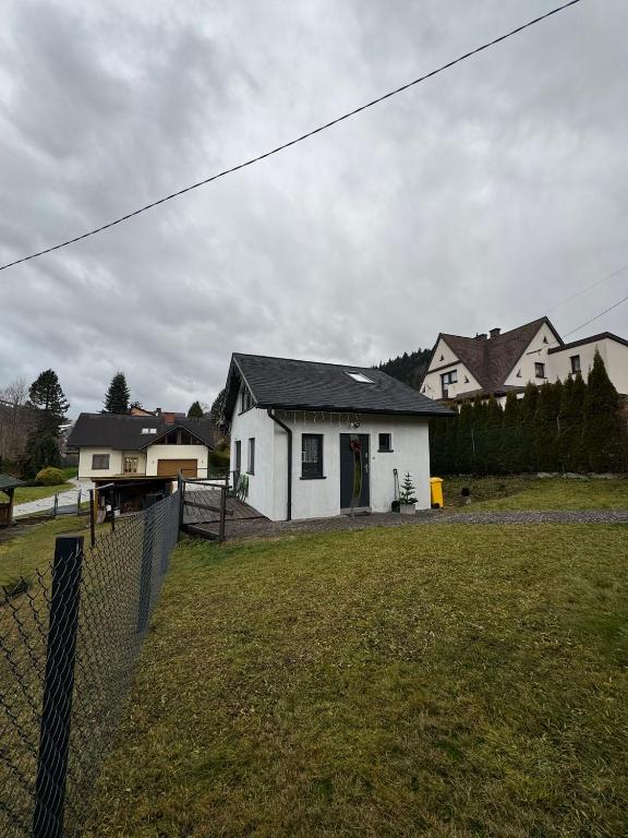 a white house with a fence in a yard at Domek na Kępce in Szczyrk