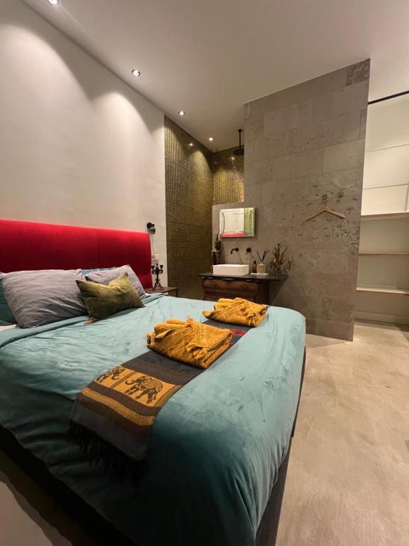 een slaapkamer met een groot bed met een rood hoofdeinde bij Boutique Amsterdam in Amsterdam
