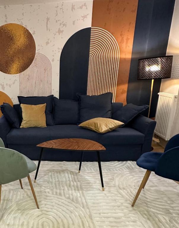 un salon avec un canapé bleu et une table dans l'établissement L'Écrin Bleu, à Aubervilliers