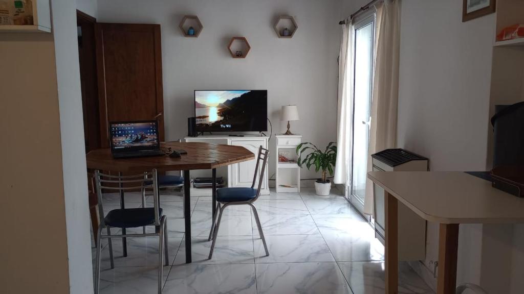 cocina con mesa y sillas y TV en Lo de Pedro Tandil, en Tandil