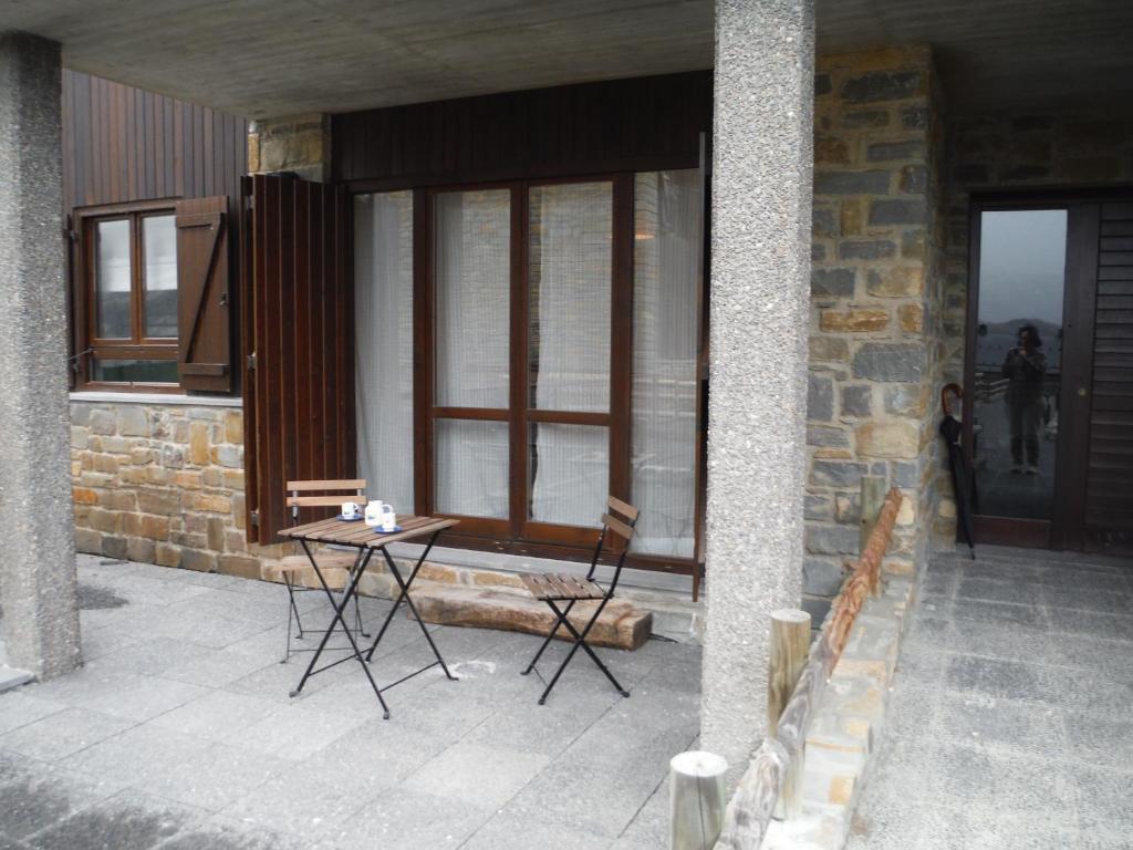 a patio with two chairs and a table in front of a building at Apartamento en Panticosa in Panticosa