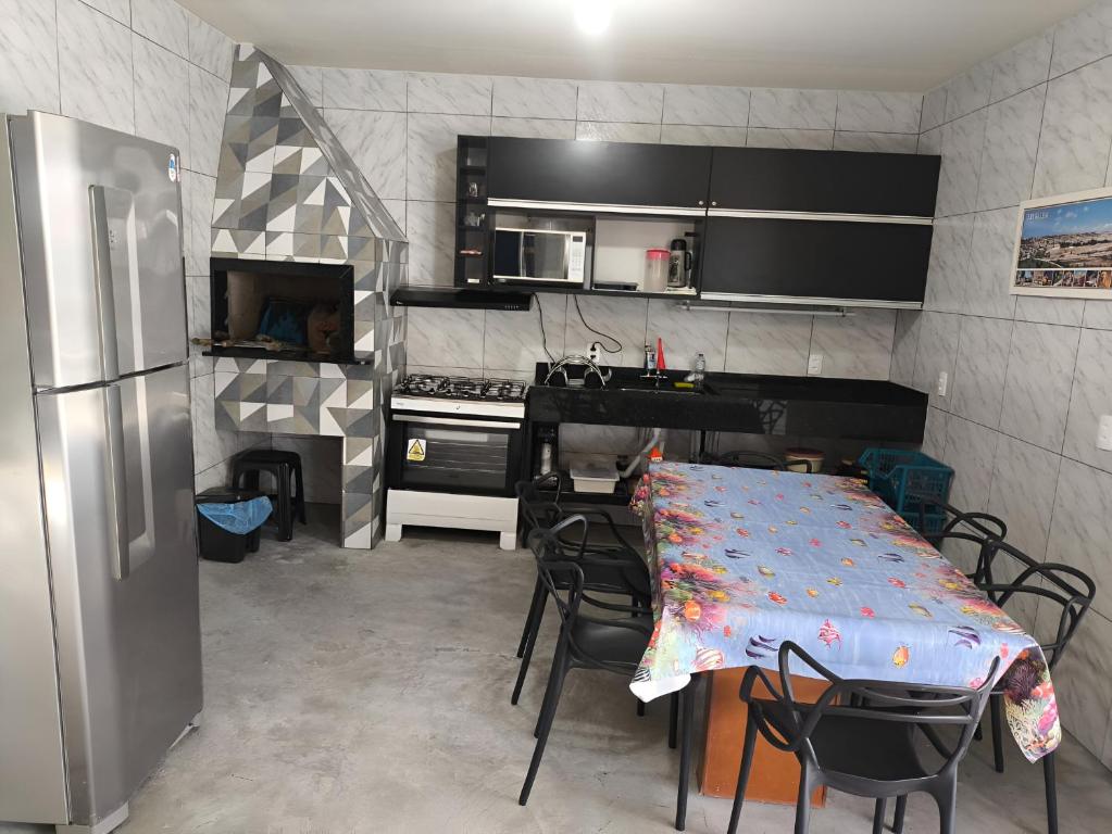 a kitchen with a table with chairs and a refrigerator at Casa de Praia Família Próximo ao ExpoCentro BC in Balneário Camboriú