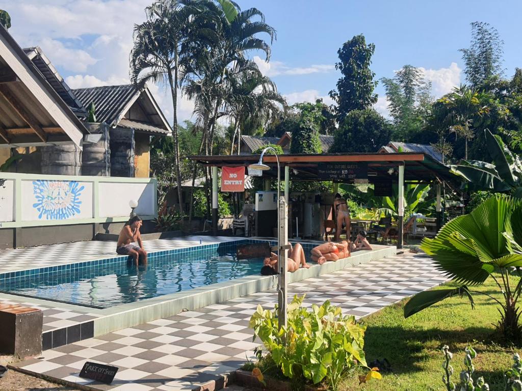 a group of people sitting around a swimming pool at Peace of Love Pai in Pai