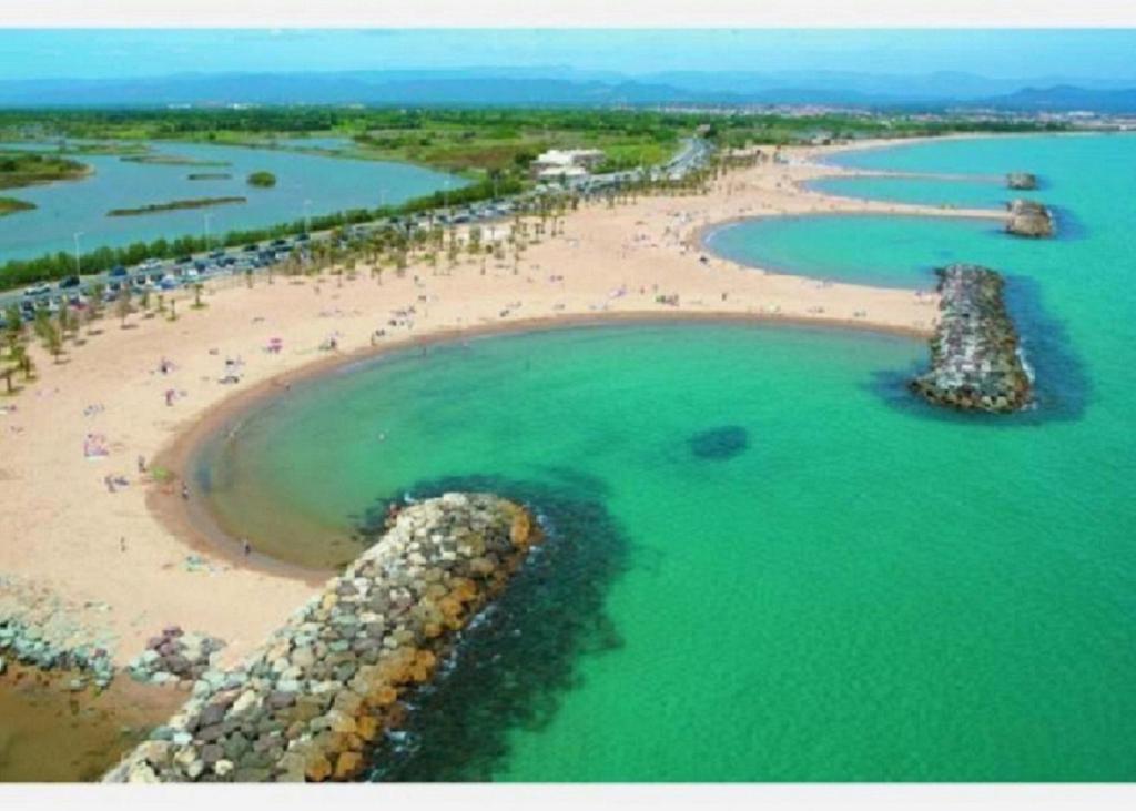 une vue aérienne d'une plage avec des gens dans l'eau dans l'établissement Chez louloute, à Fréjus