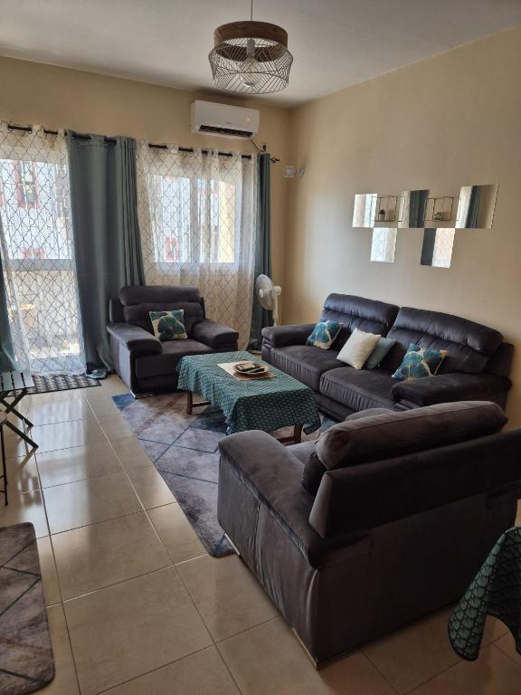 un soggiorno con due divani e un tavolo di Appartement Caraïbe a Rufisque