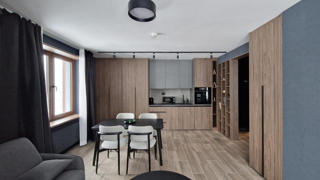 Una cocina y un comedor con mesa y sillas. en Nova Planina Jahorina, en Jahorina