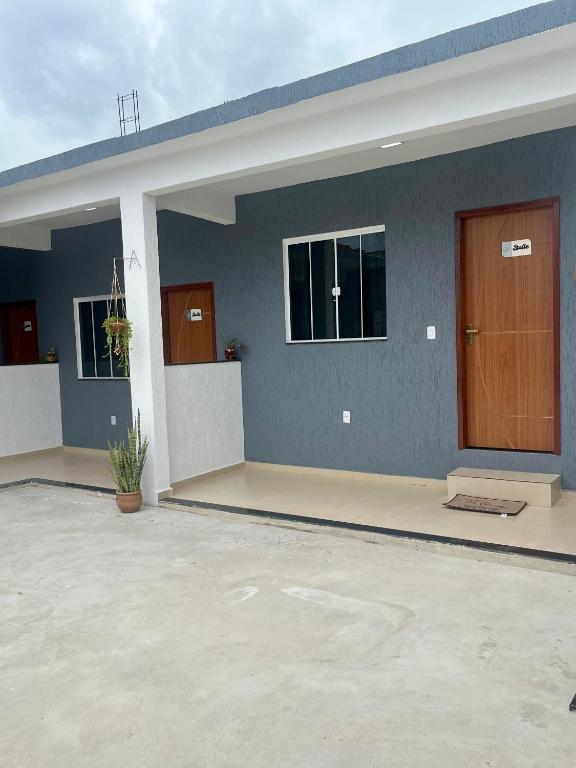 a home with a blue wall and a wooden door at Suitella in Cabo Frio