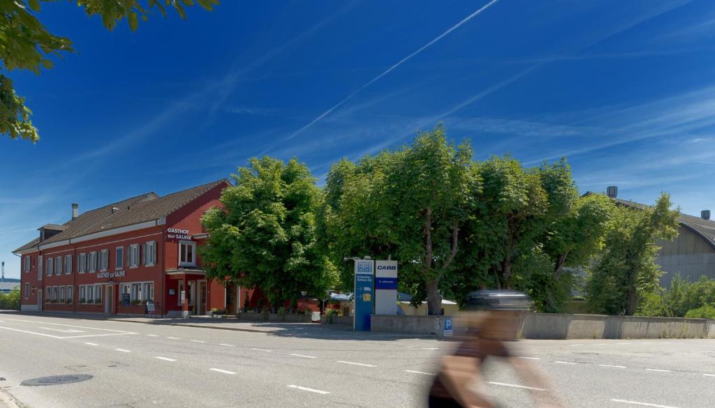 una mujer montando una bicicleta por una calle en Gasthof zur Saline, en Pratteln