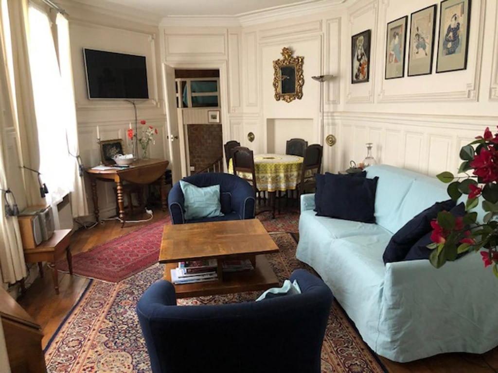un salon avec un canapé bleu et une table dans l'établissement Le 35 rue Coquillière with airport pick-up service, à Paris