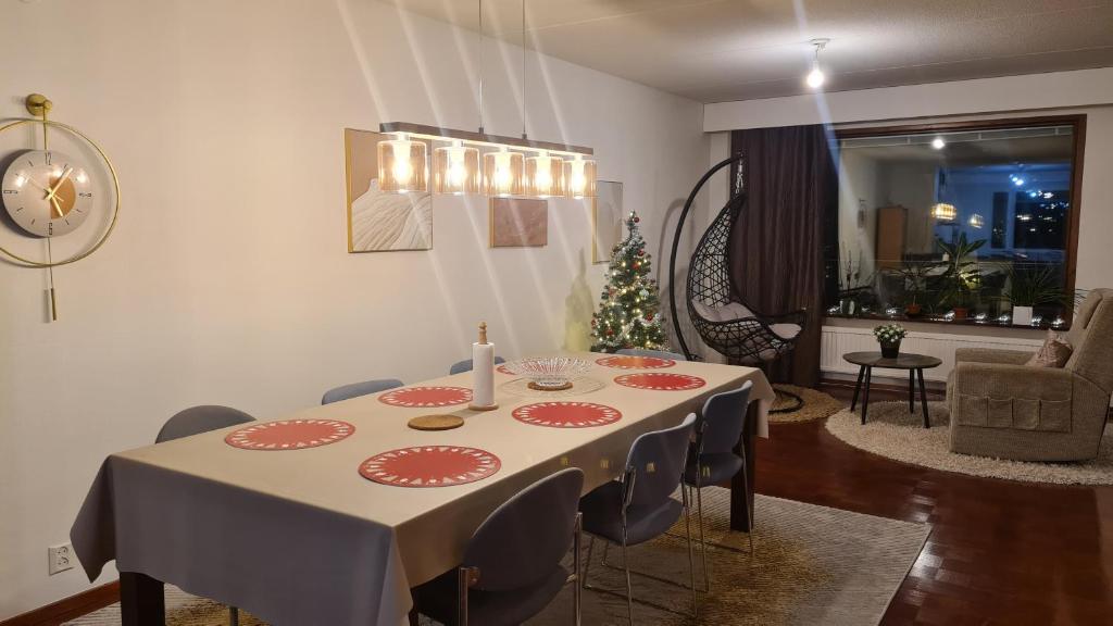 a dining room with a table and a christmas tree at 3-bedroom lake view and near center apartment with sauna in Lahti