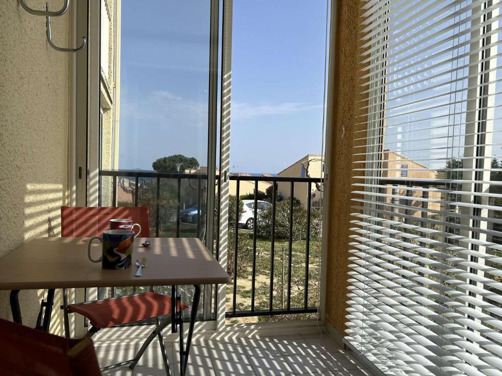 d'un balcon avec une table et une fenêtre offrant une vue. dans l'établissement SP570-391 Appartement 2 pièces ST PIERRE LA MER, à Saint Pierre La Mer