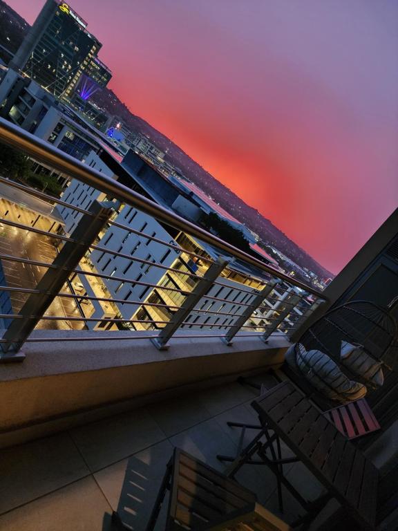 a view from the balcony of a building at sunset at Modern Apartment with Sunbet Casino view in Pretoria