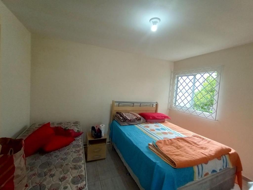 une chambre avec un lit et une fenêtre dans l'établissement Tree-lined beach house, à Matinhos
