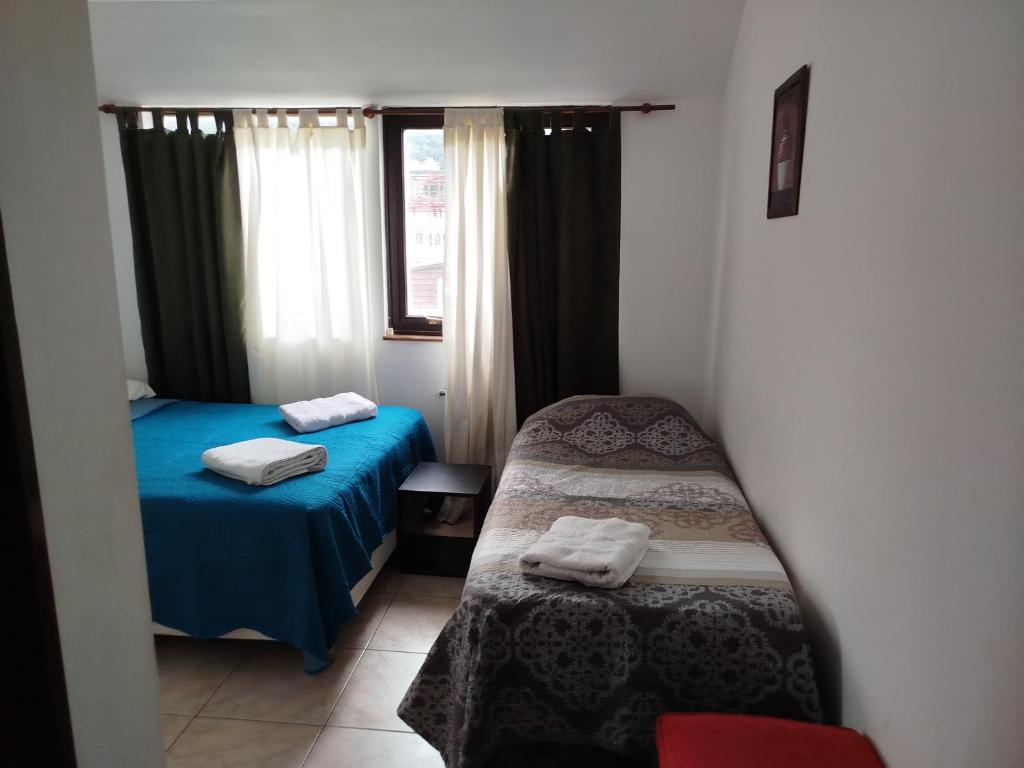 a small room with two beds and a window at Departamento Centro Ushuaia in Ushuaia