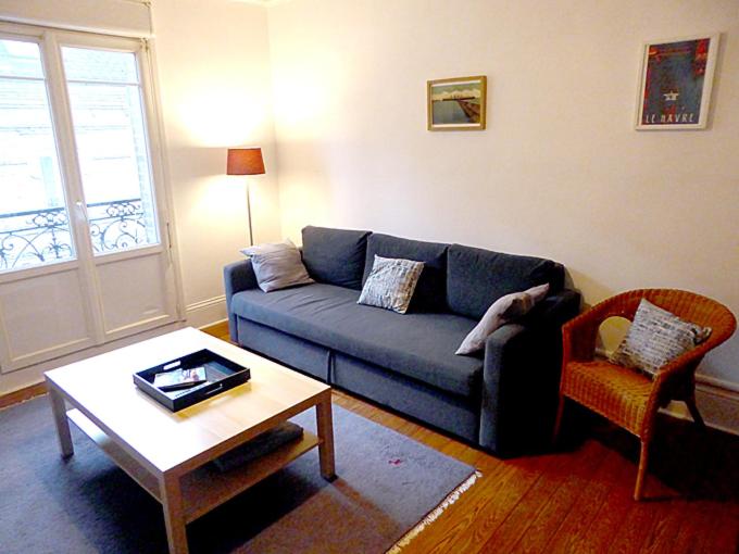 un salon avec un canapé bleu et une table basse dans l'établissement Spacieux T2 proche gare, au Havre