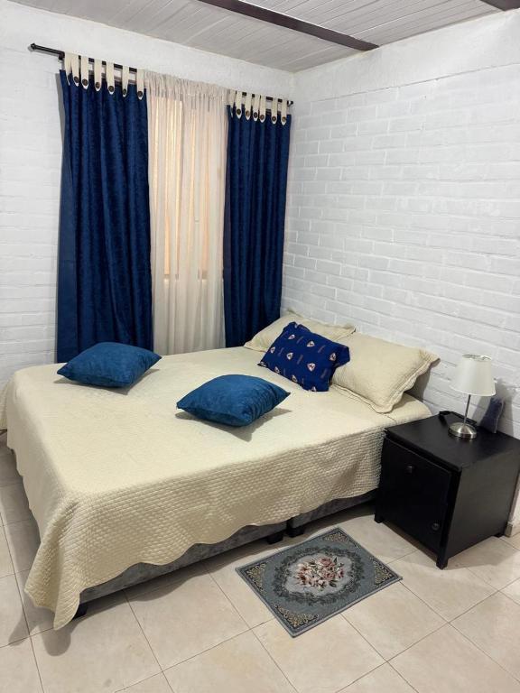 a bedroom with two beds with blue pillows at Acogedor Aparta estudio central in Popayan