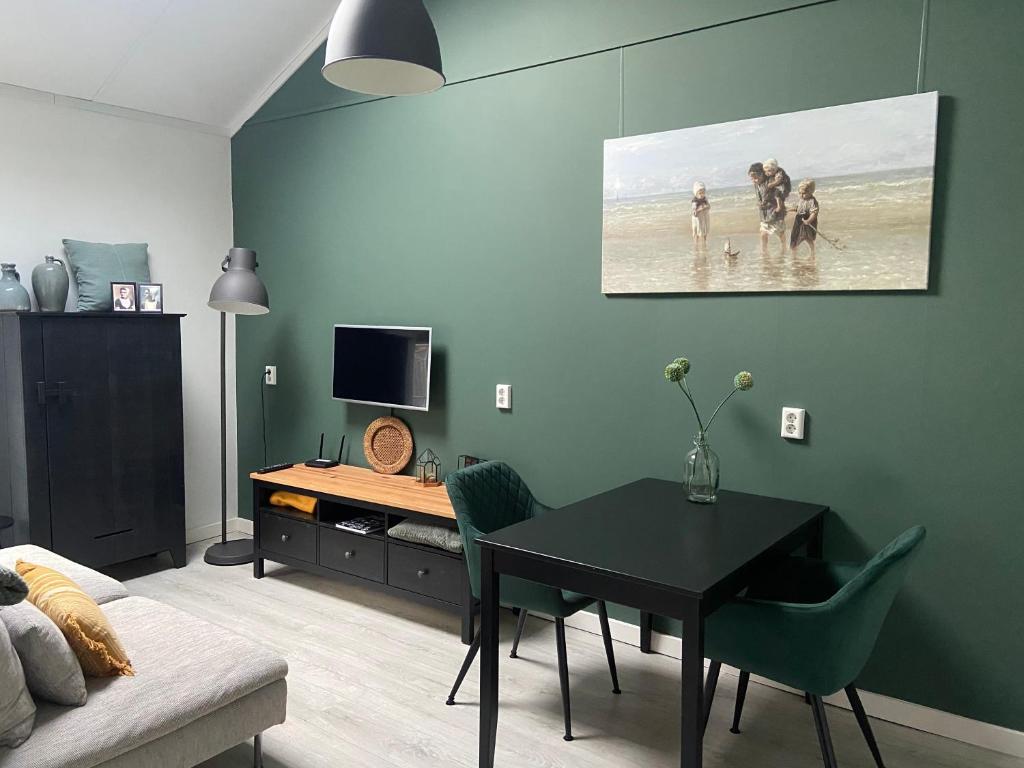 a living room with a dining room table with people on the beach at Zon en Zee 2 personen in Westkapelle