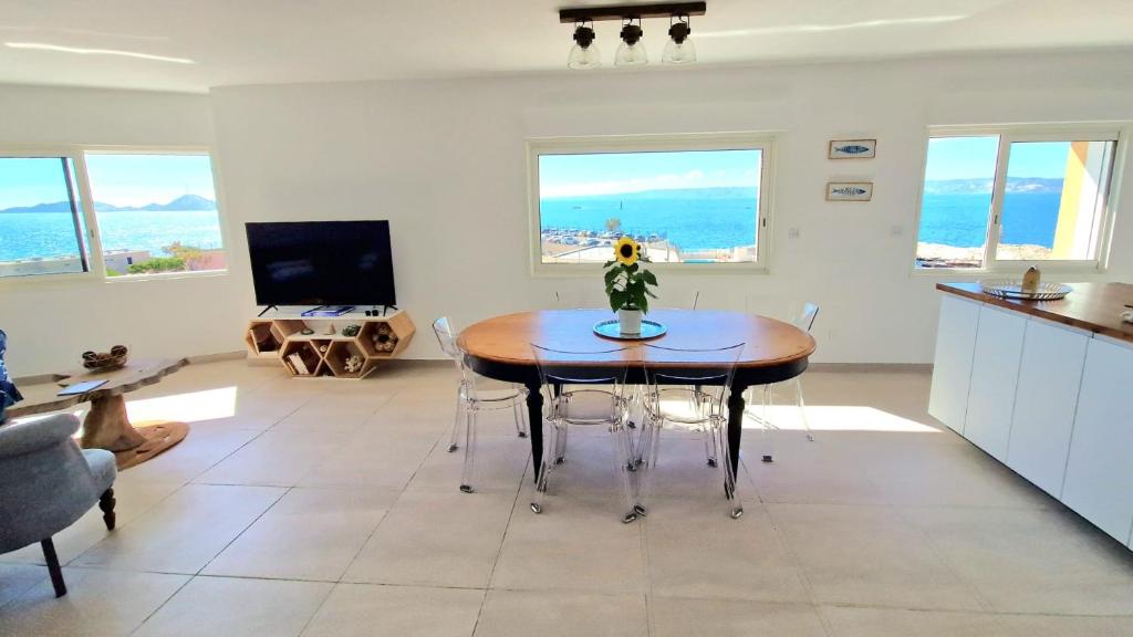 une cuisine et un salon avec une table et des chaises dans l'établissement Magnifique Vue Mer Malmousque, à Marseille