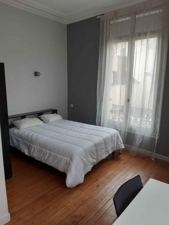 une chambre avec un grand lit et une grande fenêtre dans l'établissement Studio proche gare - 4, au Mans