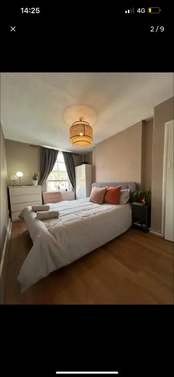 a bedroom with a large white bed with a chandelier at Cute apartment in London