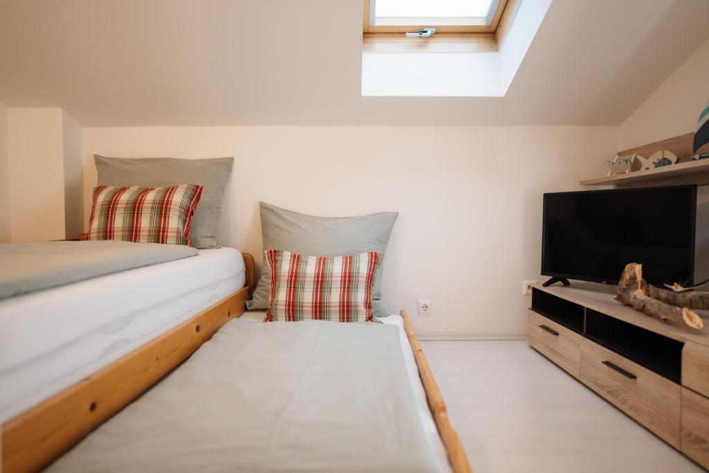 a small room with a bed and a flat screen tv at Schwalbennest Velden in Velden am Wörthersee