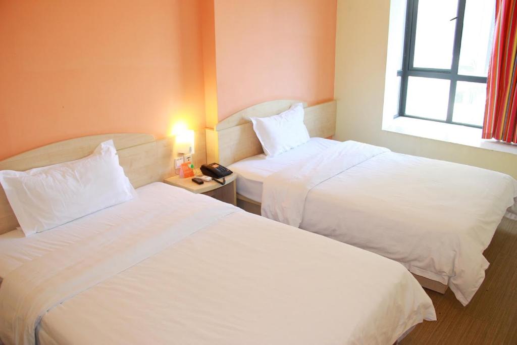 Cette chambre comprend 2 lits et une fenêtre. dans l'établissement 7Days Inn Dongguan Houjie Conference & Exhibition Center, à Dongguan