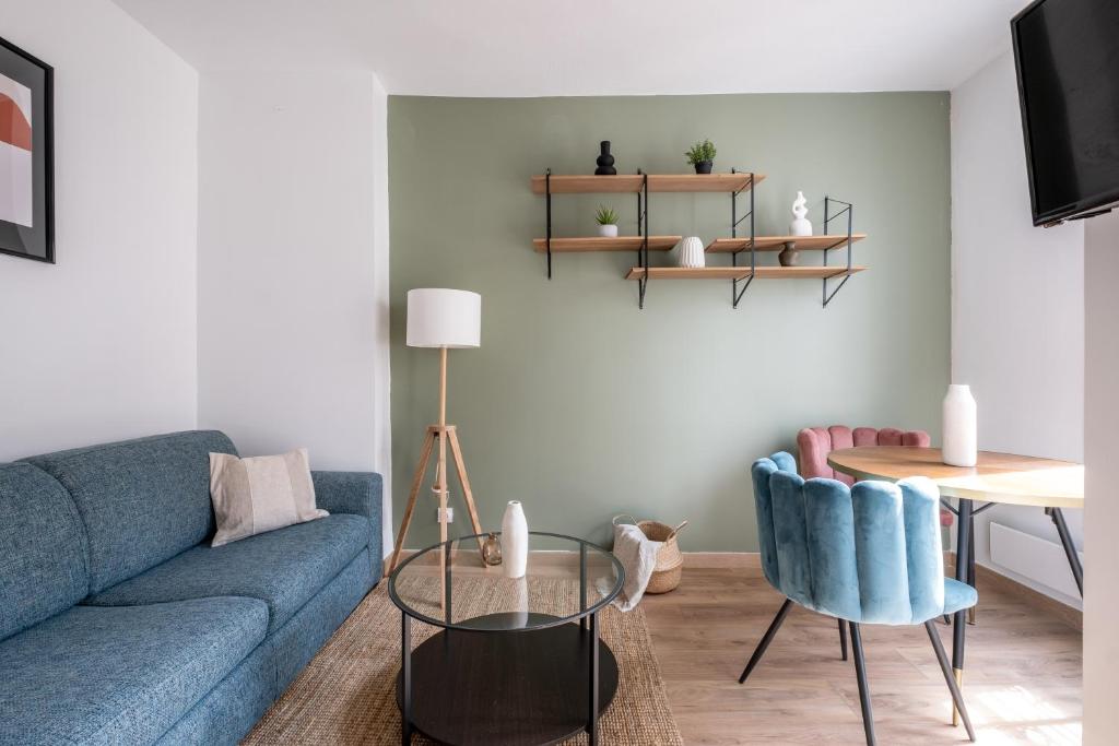 un salon avec un canapé bleu et une table dans l'établissement Appartement Cozy à Paris, à Paris
