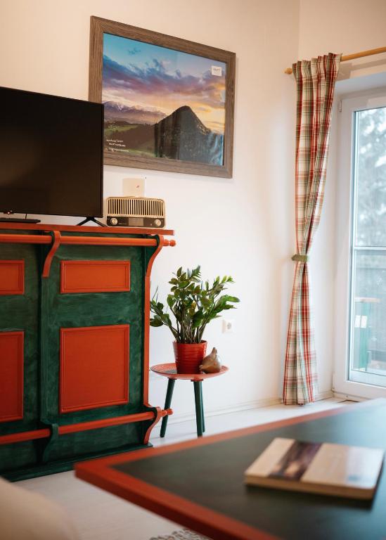a living room with a green fireplace and a tv at Schwalbennest Velden in Velden am Wörthersee