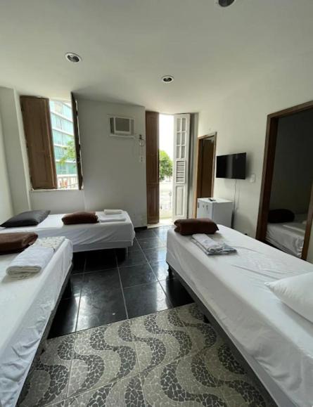 a room with two beds in a room at Suíte 101 - Pousada no Centro do Rio in Rio de Janeiro