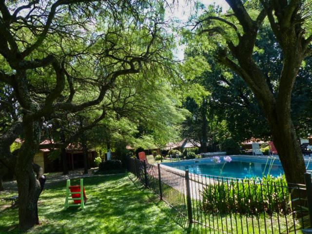 a fence next to a swimming pool in a yard at Hostal La Merced in Villa General Belgrano