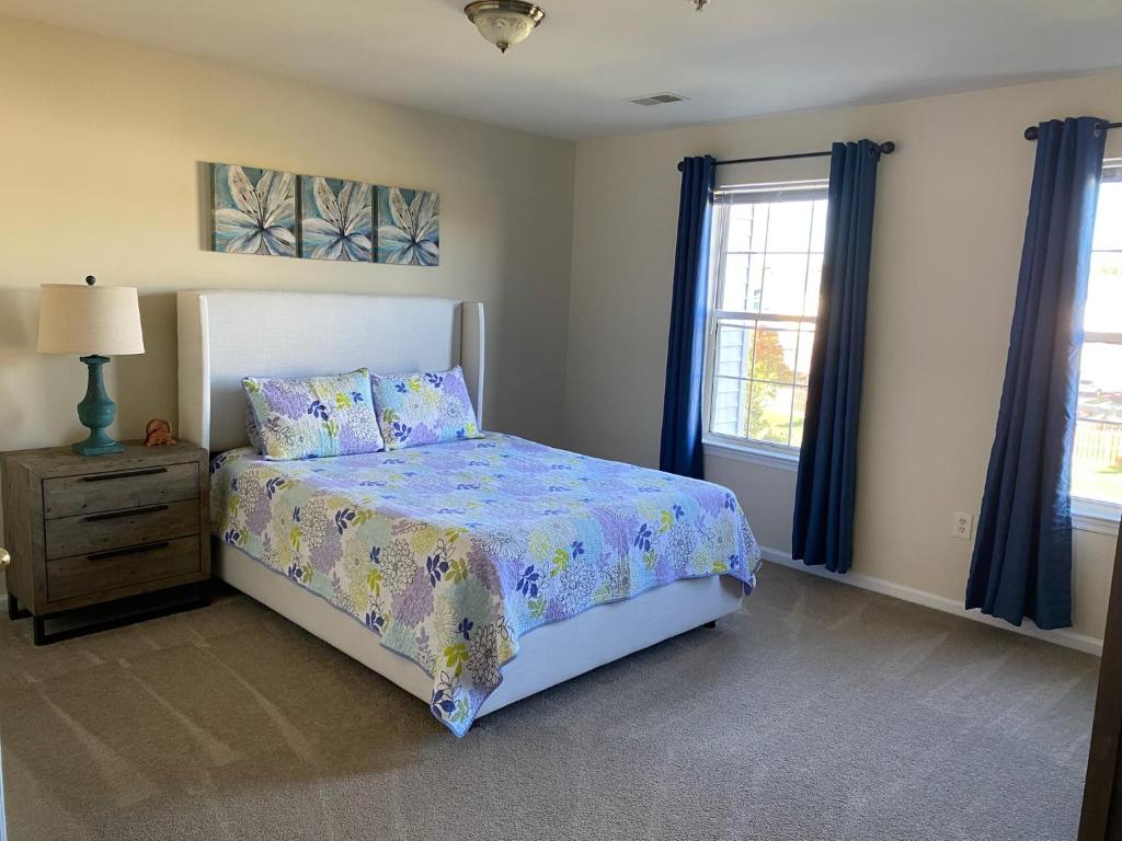 Un dormitorio con una cama, una cómoda y ventanas. en Cozy 3 bedrooms towhouse, en Frederick