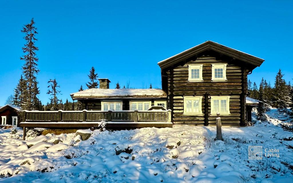 a log cabin in the snow in front at Large log cabin at Sjusjøen with sauna, fireplace and panoramic view in Ringsaker