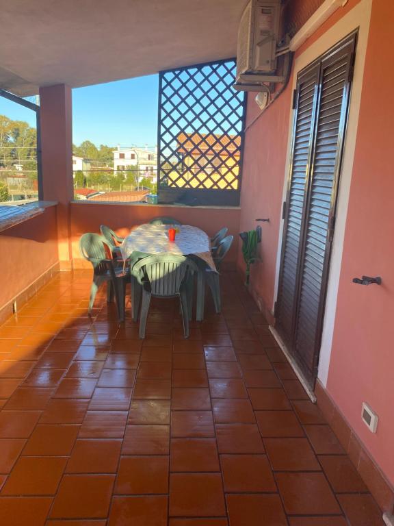 a table and chairs in a room with a window at CasadellemeravigliediGiulia in Ostia Antica