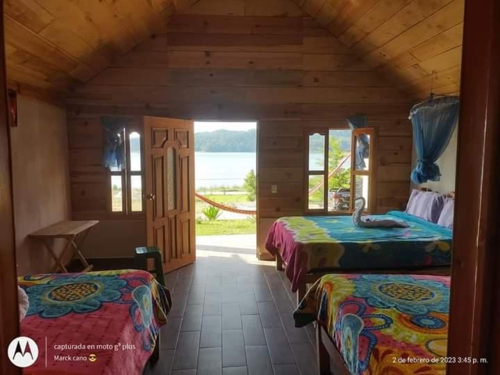 a room with three beds and a view of the water at Cabañas la frontera in Santiago