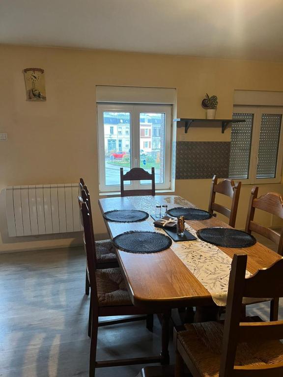 une table à manger avec des chaises et une grande table en bois dans l'établissement Appartement calme, frais à louer, nouvellement repeint, emplacement stratégique, proche de toutes commodités, de l'autoroute, valenciennes, lille, Belgique, wifi, Netflix, parking Gratuits, à Raismes