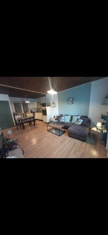 un salon avec un canapé et une table dans l'établissement Belle maison indépendante 3 chambres séjour à 25 minutes de Clermont-Ferrand, à La Monnerie-le Montel