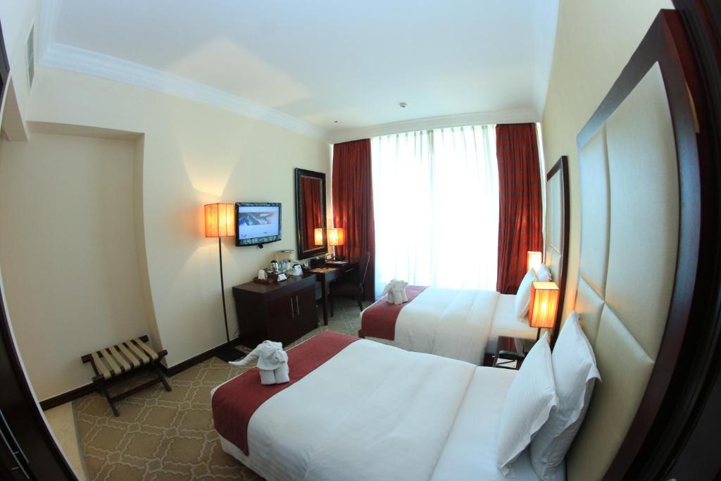Postel nebo postele na pokoji v ubytování Grand Regal Hotel