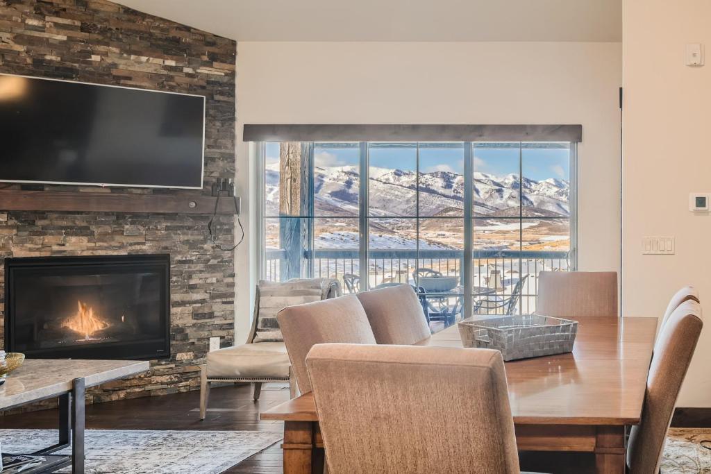 a living room with a fireplace and a table and chairs at Private Hot Tub, Close to Resorts - Private Hot Tub - Close to PC, Mountain Mansion Family Getaway in Park City