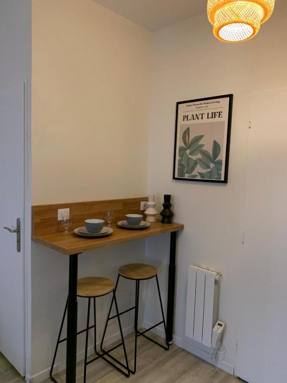 une petite table avec deux tabourets dans une pièce dans l'établissement Escale Élégante Nancy, à Nancy