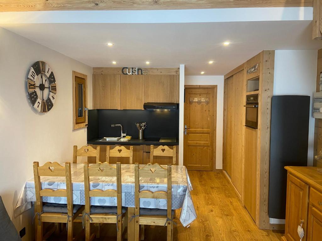 une cuisine avec une table et des chaises dans une pièce dans l'établissement Everest Appt 6 pers ski aux pieds, à La Clusaz