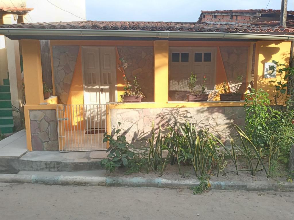 Una pequeña casa con plantas delante de ella. en Casa Bacana Boipeba, en Isla de Boipeba