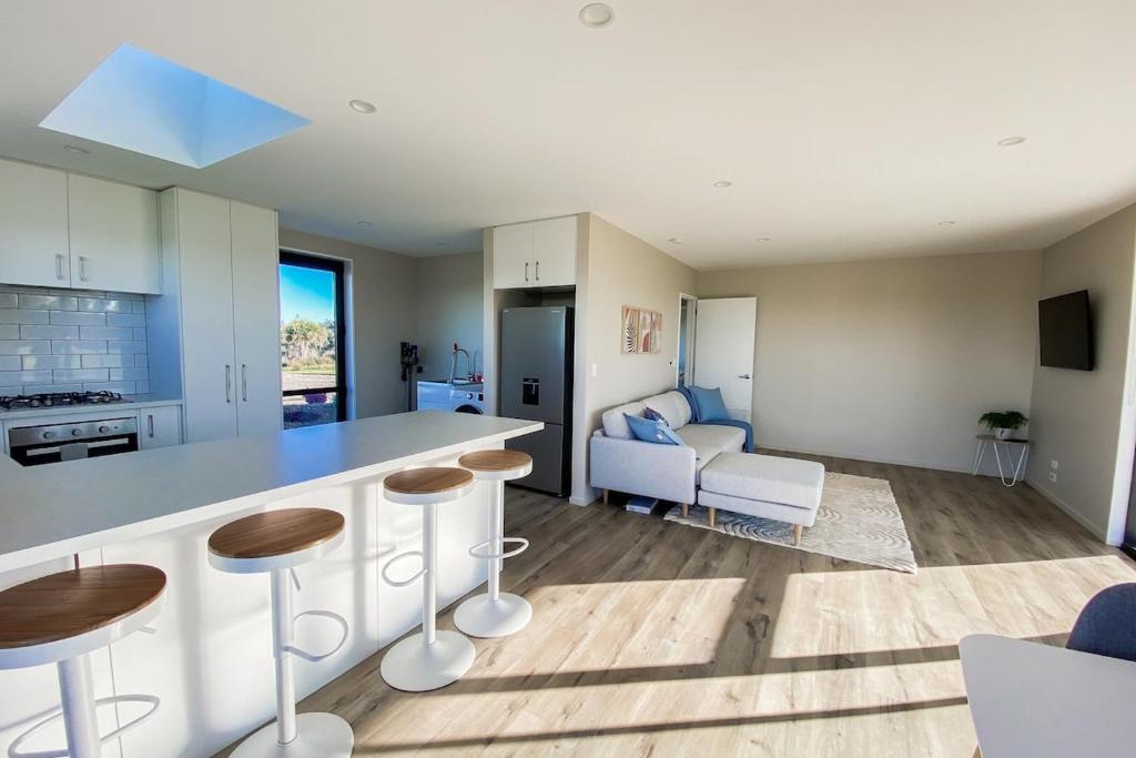 a kitchen and living room with a counter and chairs at Country Cottage in Sefton